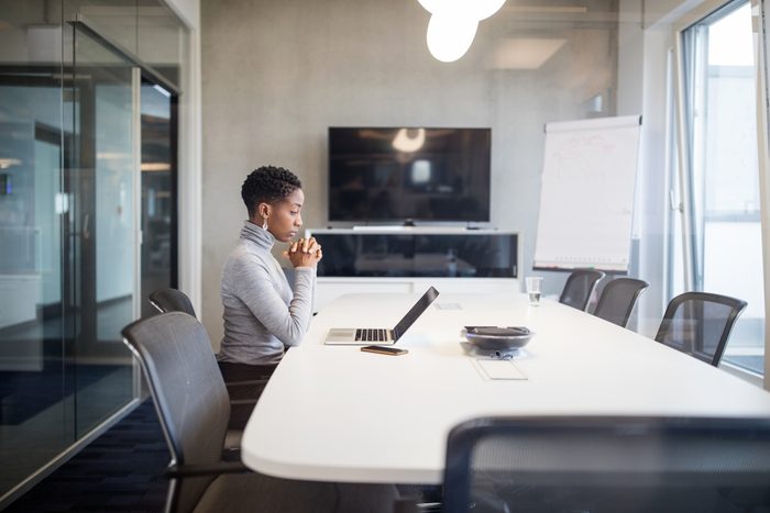 Businesswoman sitting at conference table with laptop