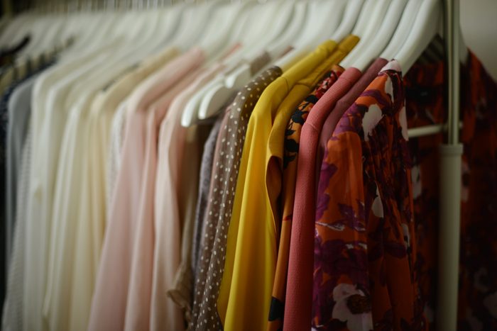 blouses arranged by color hanged on hangers in a row