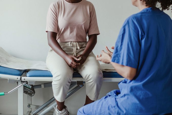 Female doctor discussing with patient in medical room at hospital