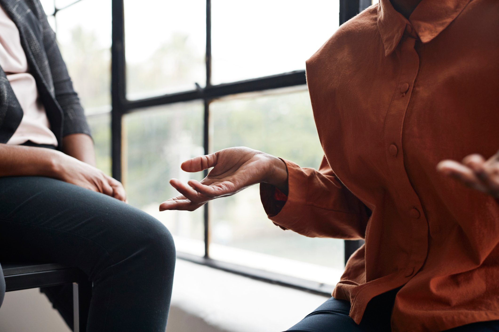 Businesswoman gesturing by window at workplace