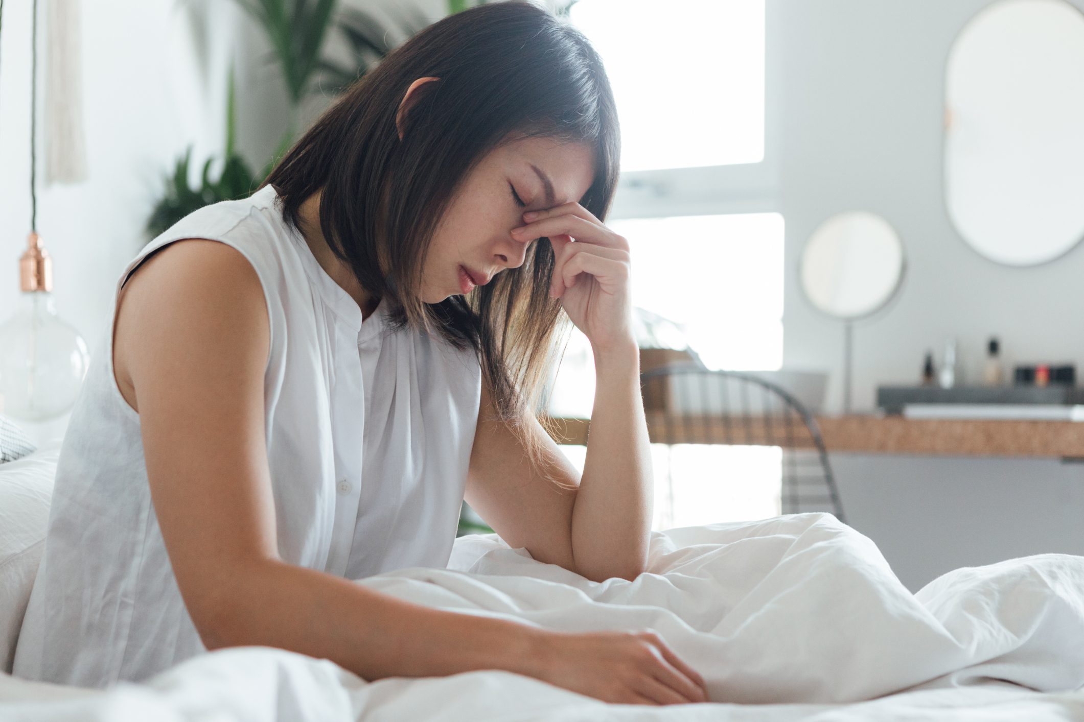 woman with headache sitting in bed