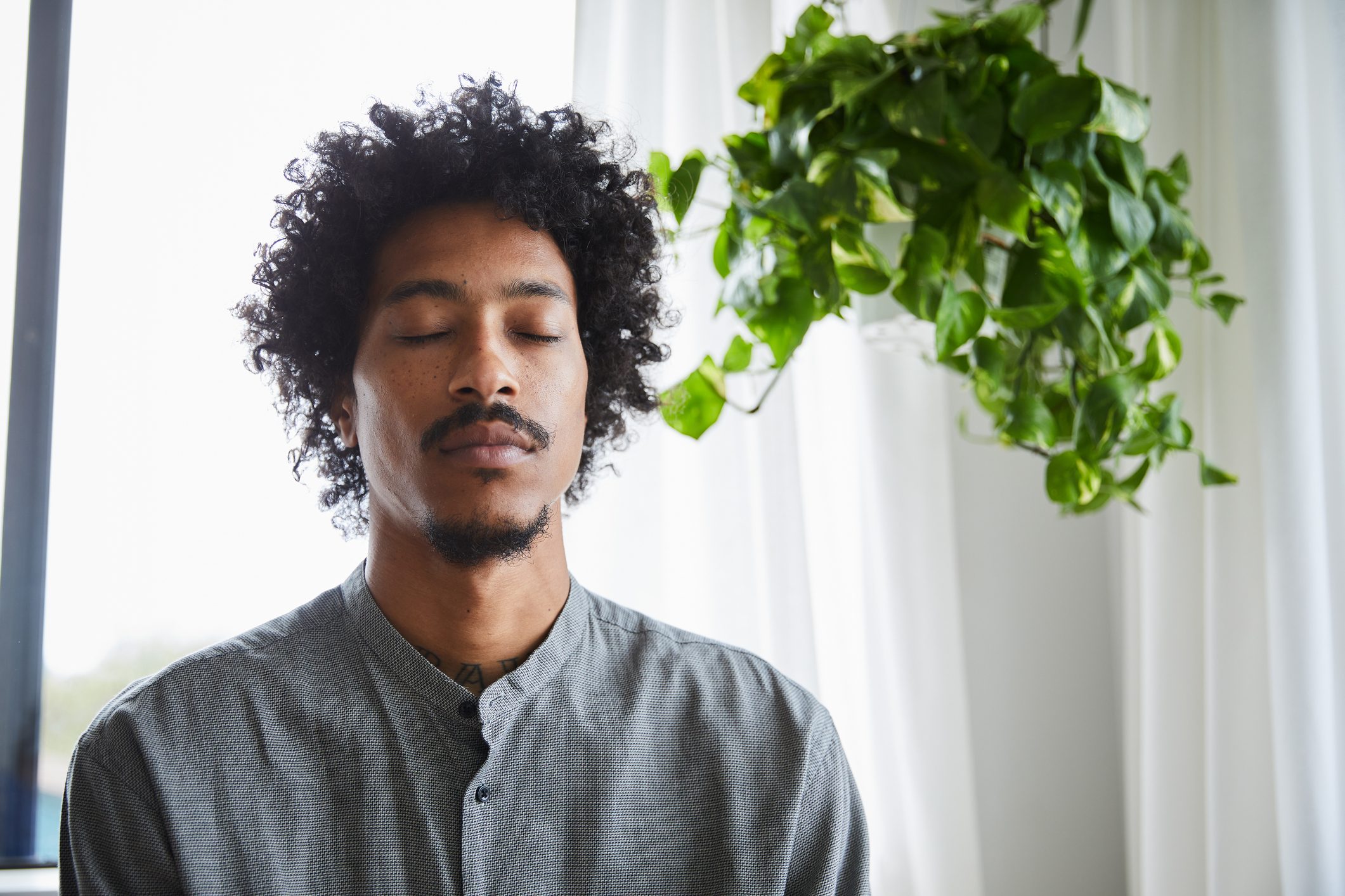 Young man meditating at home in the afternoon