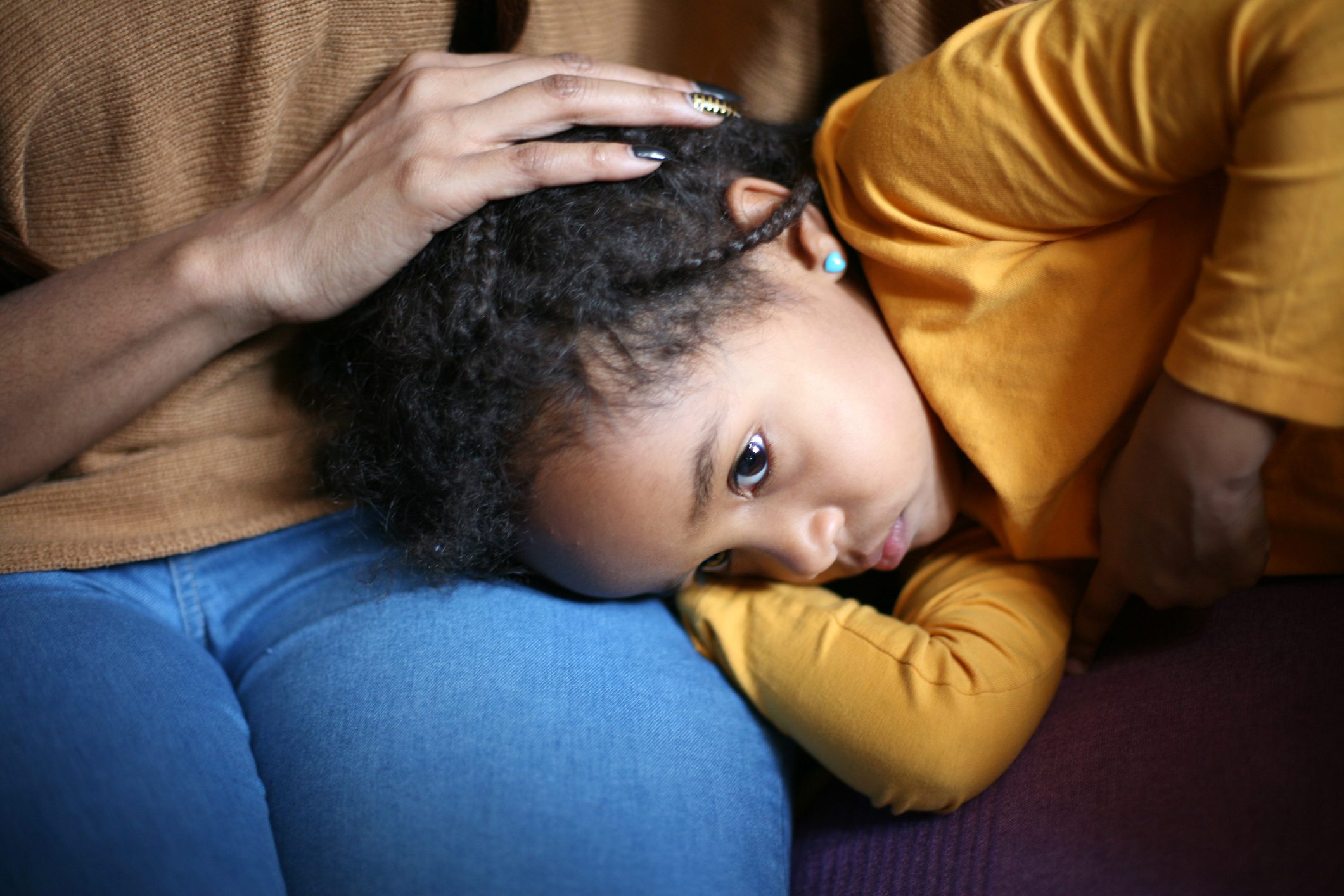 little girl lying on couch with her mother