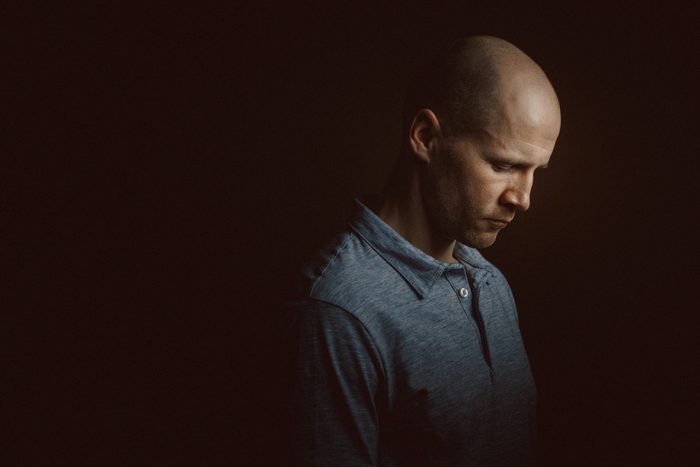 depressed man with head down in dark room