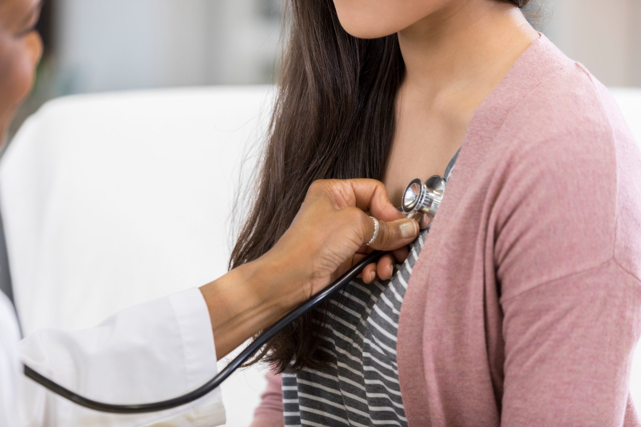 Doctor listening to patient's heartbeat