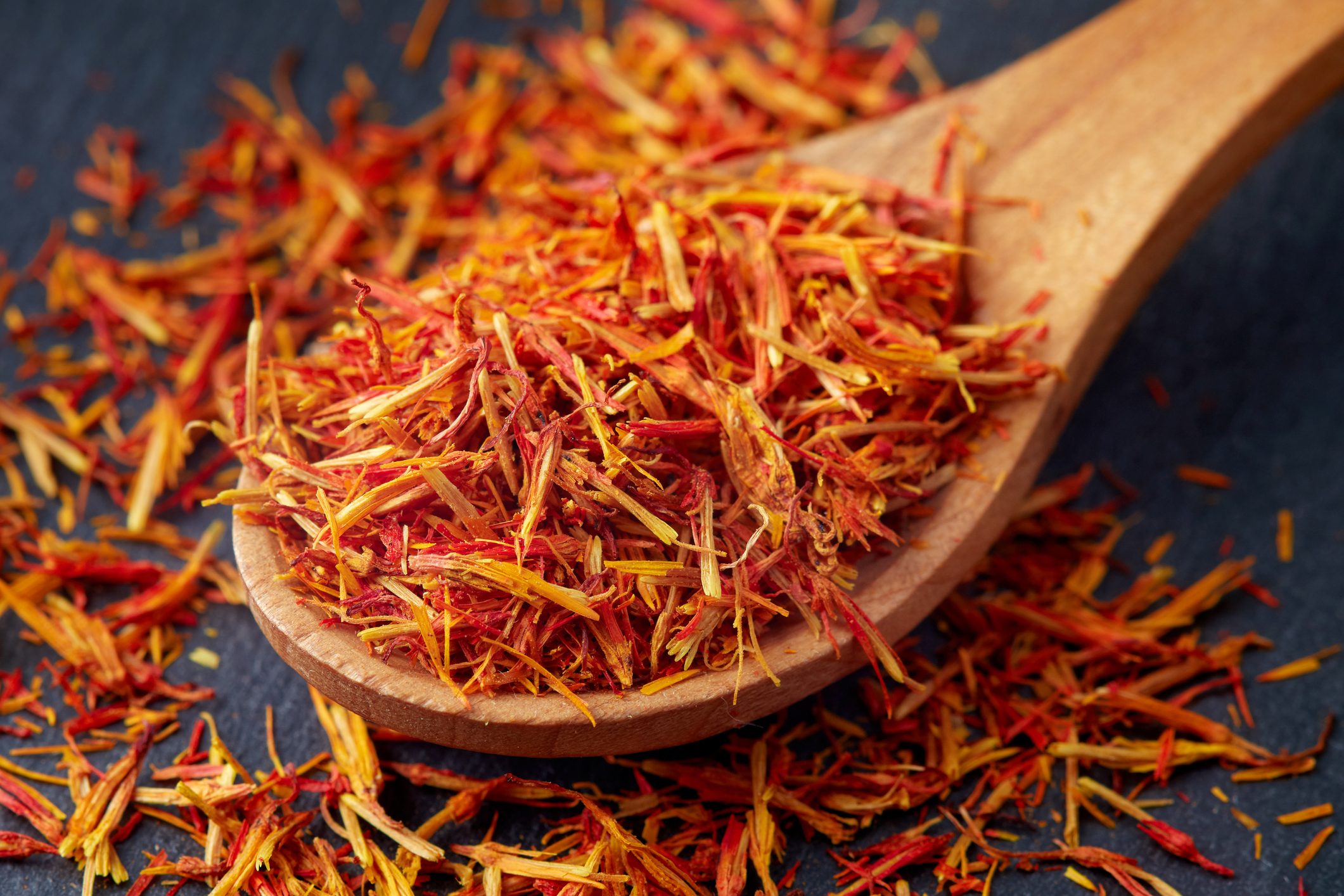 Safflower petals in a wooden spoon