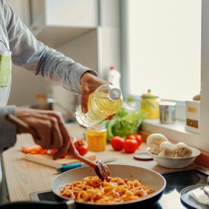 Woman adding olive from bottle