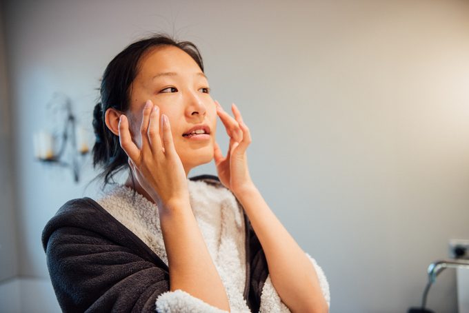 A young woman is washing her face