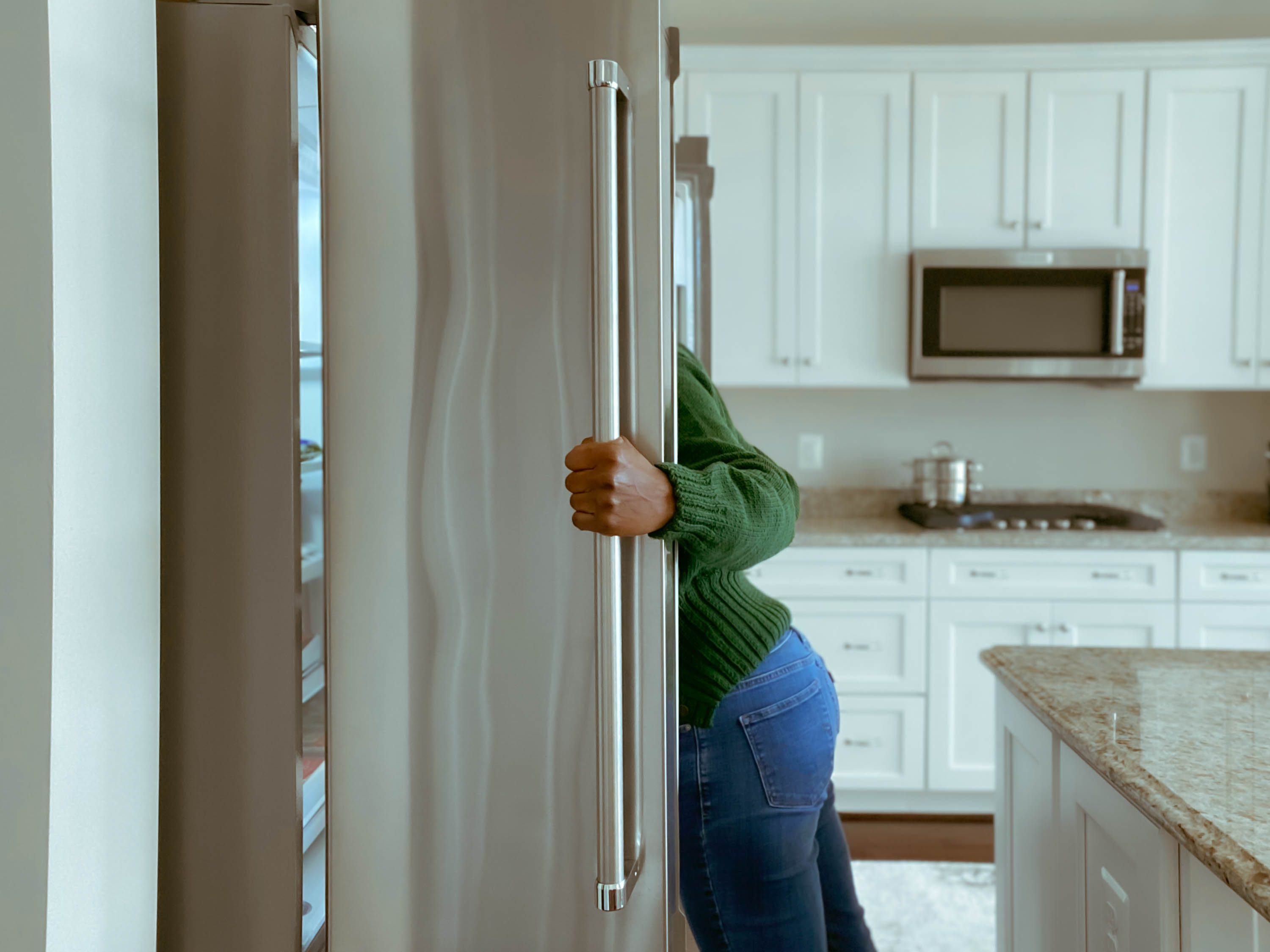 woman looking in refrigerator