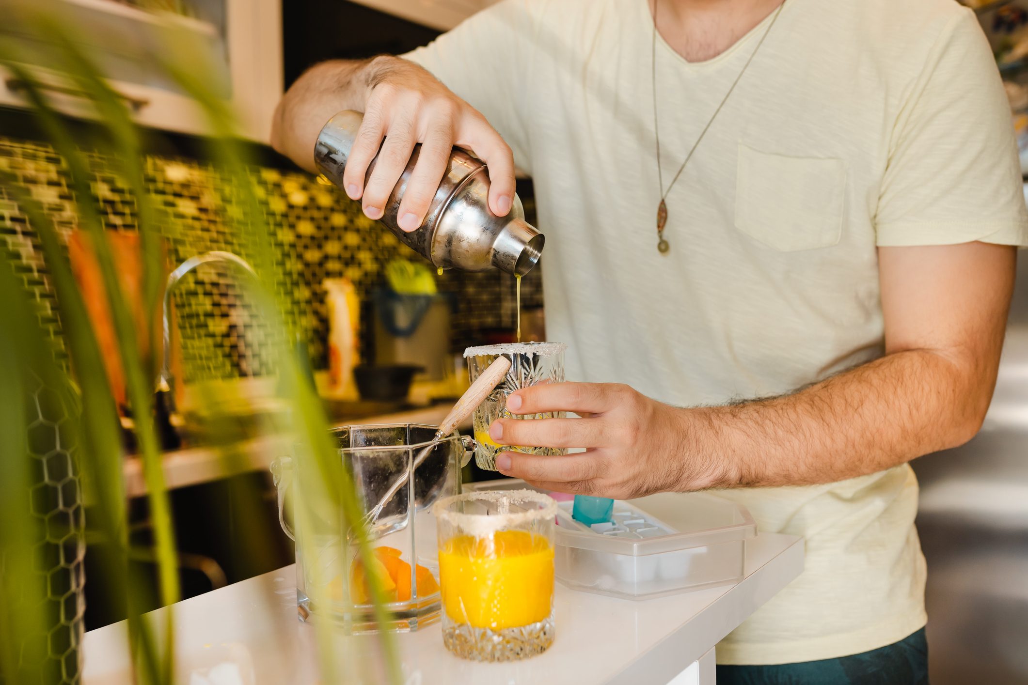 Young Adult Making Cocktails and having fun at Home