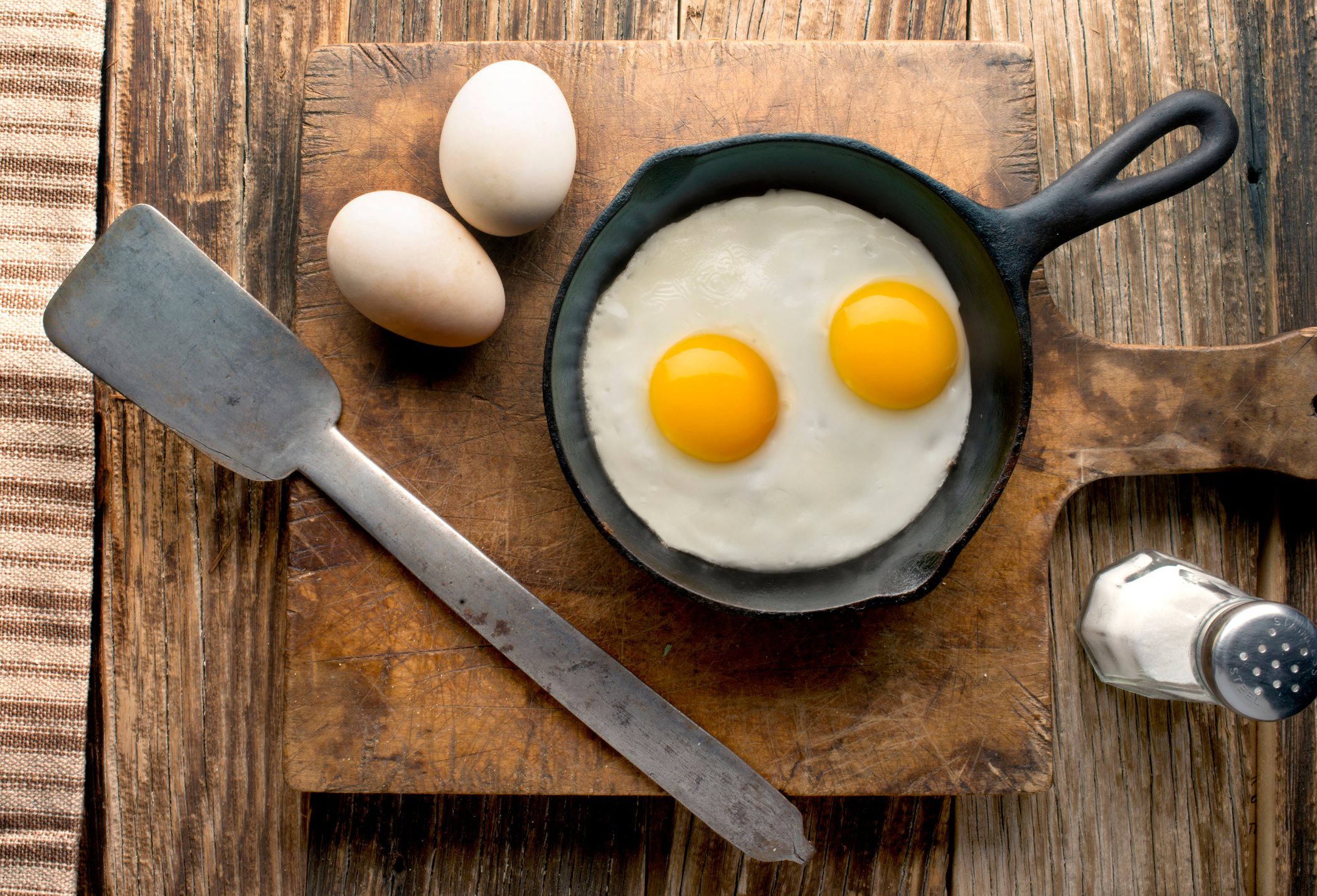 eggs in cast iron skillet on wood overhead