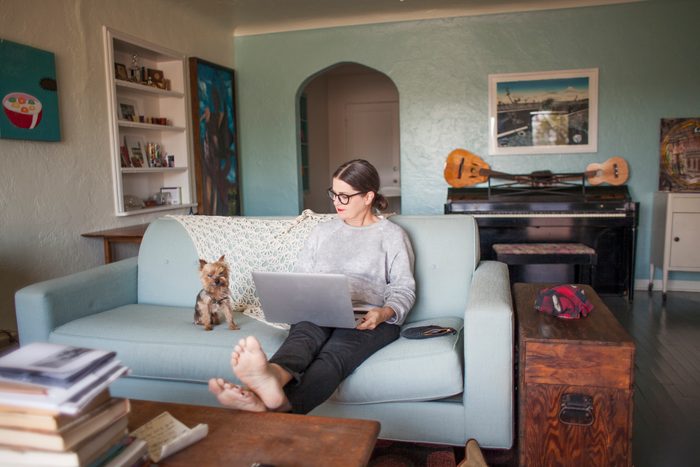 Woman sitting on couch with laptop computer