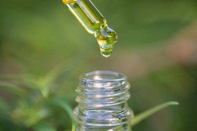 Droplet hemp oil into a glass bottle, CBD Hemp oil, Concept of herbal alternative medicine.Scientific research.
