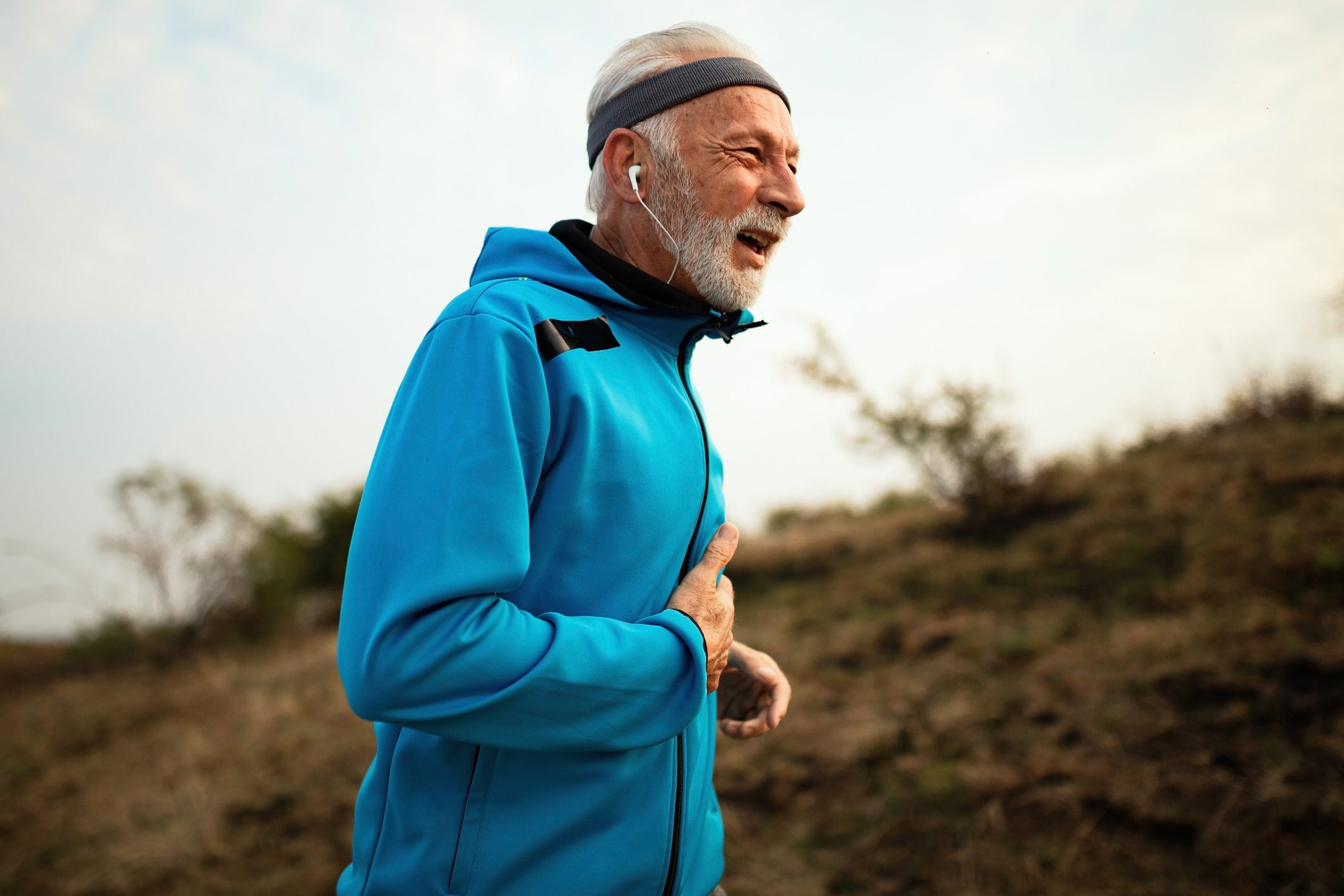 mature runner experiencing pain while jogging in nature