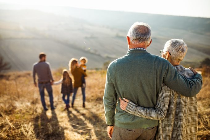 embraced senior couple looking at their family in nature
