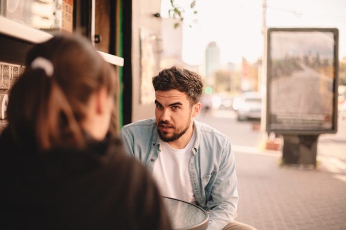 Couple talking while sitting at sidewalk cafe