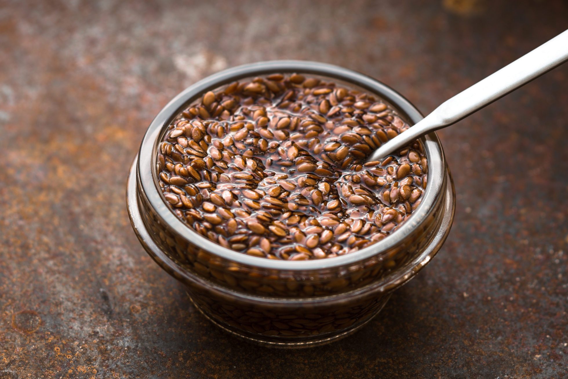 Bowl with flax seeds in water on metal background horizontal