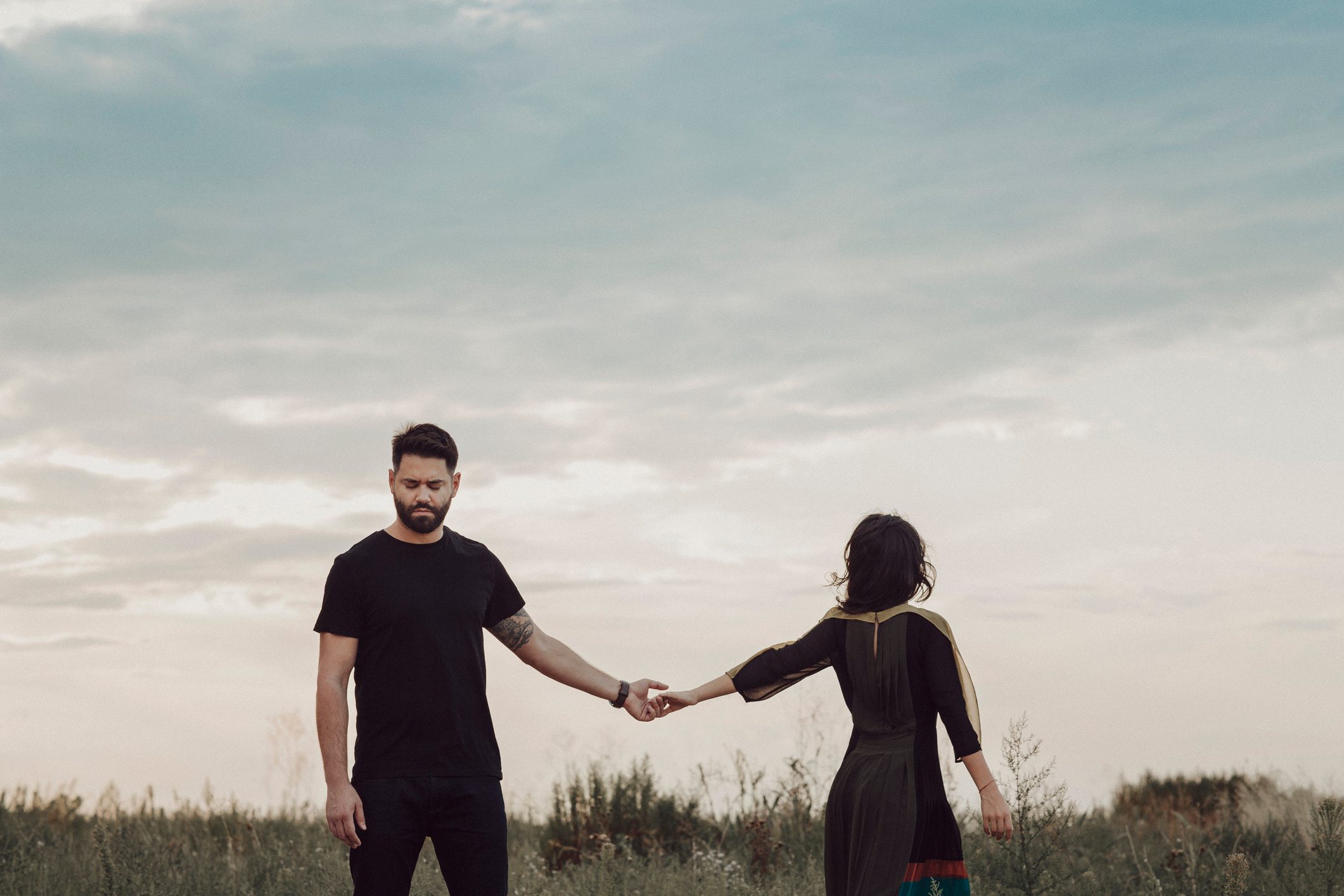 Couple in field holding hands