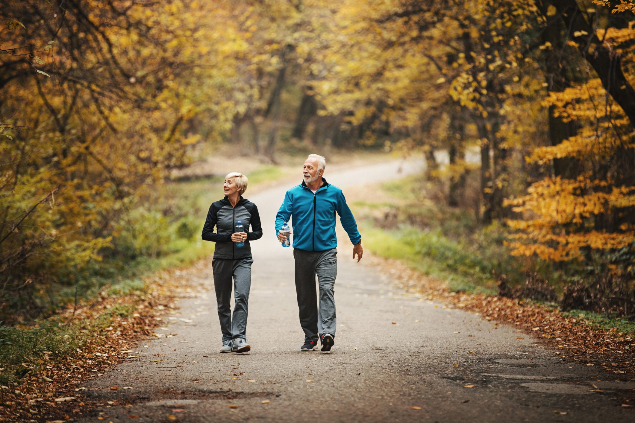 Senior couple power walking in a park.