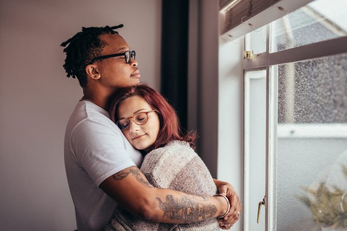 couple hugging near window