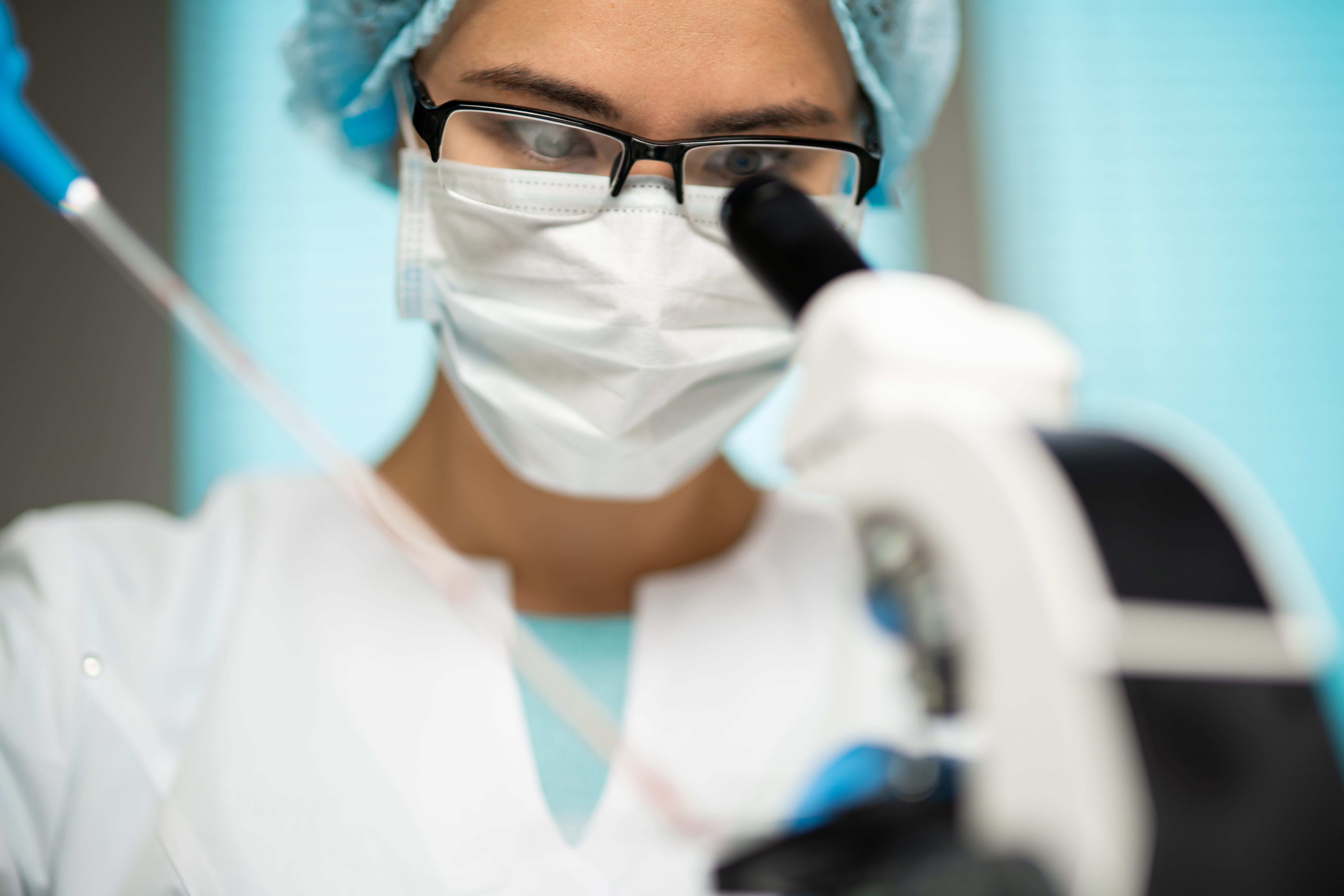 Doctor looking into microscope