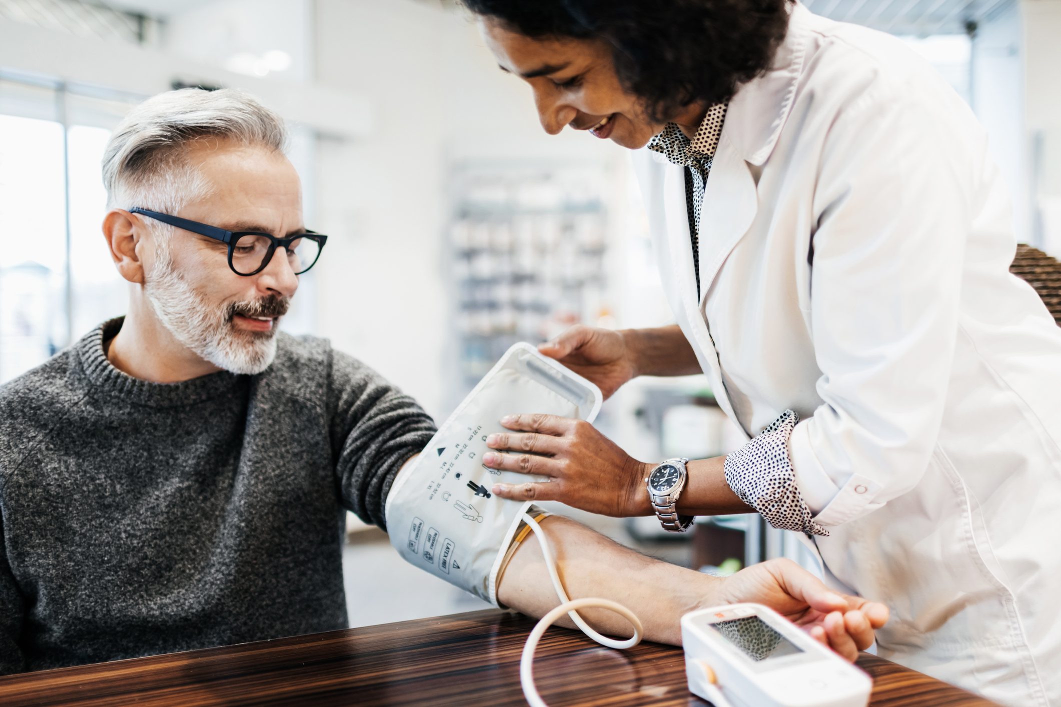 Pharmacist Measuring Man's Blood Pressure