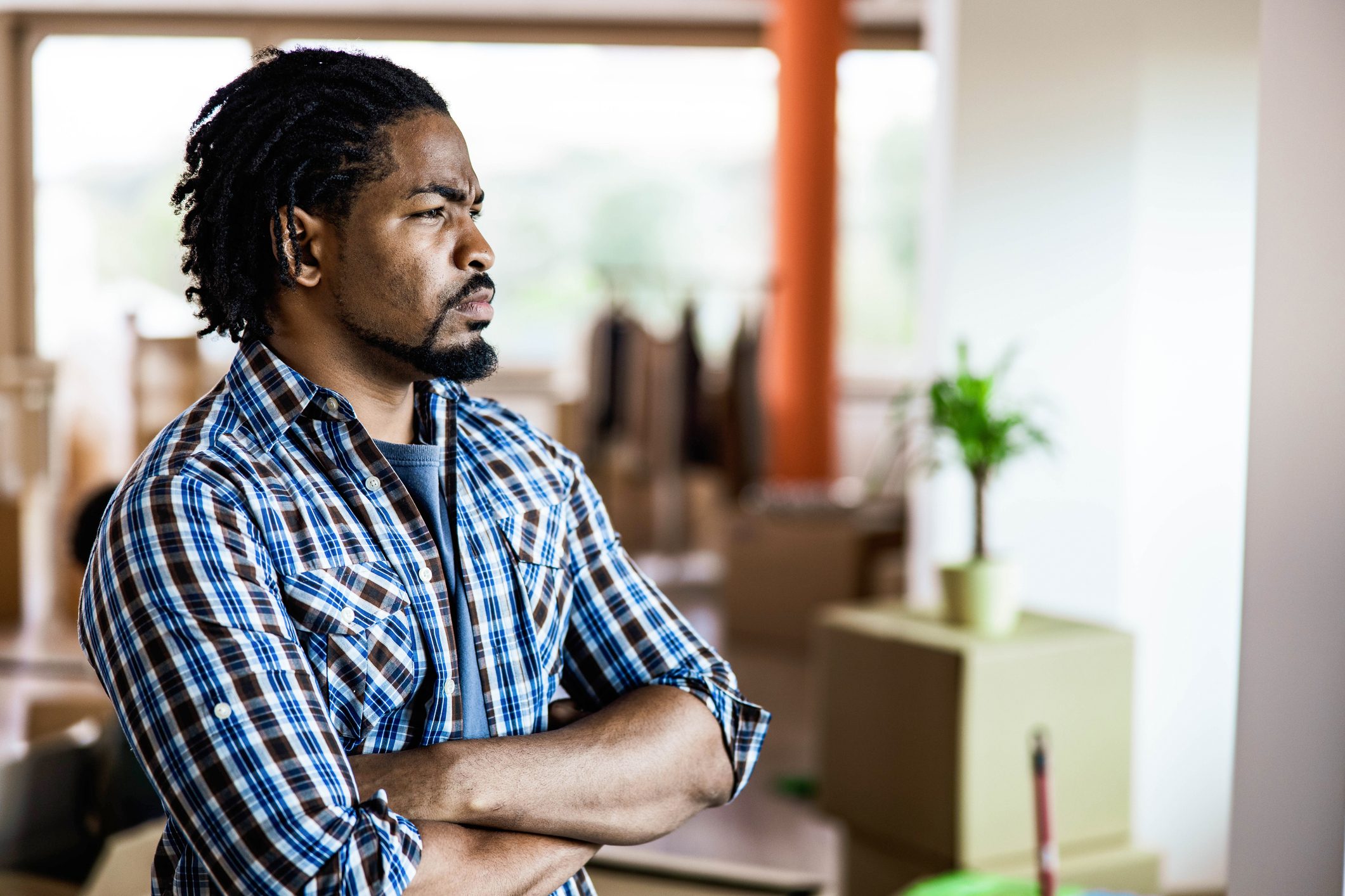 Serious black man with crossed arms in his new home.