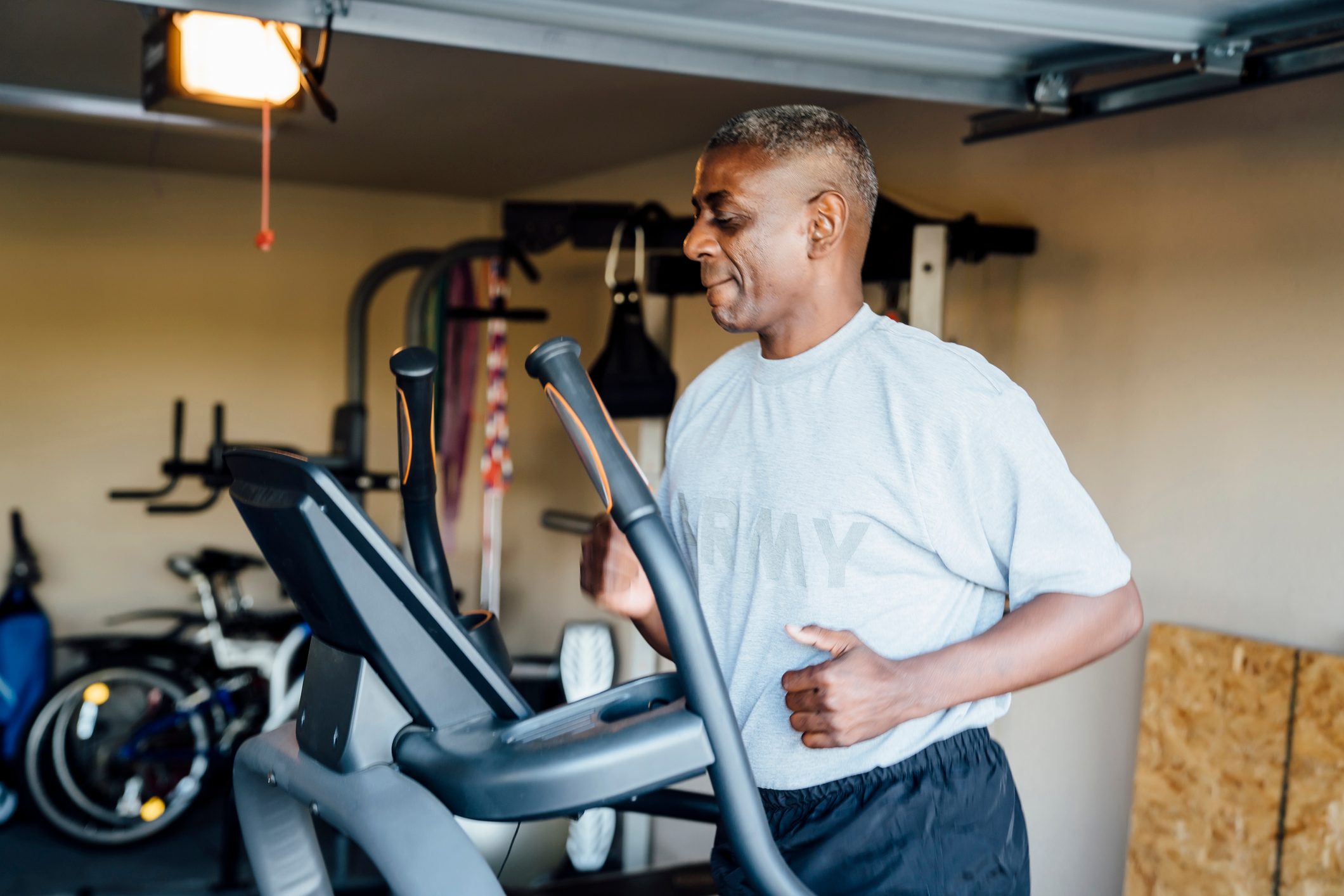 Black man running on treadmill in garage