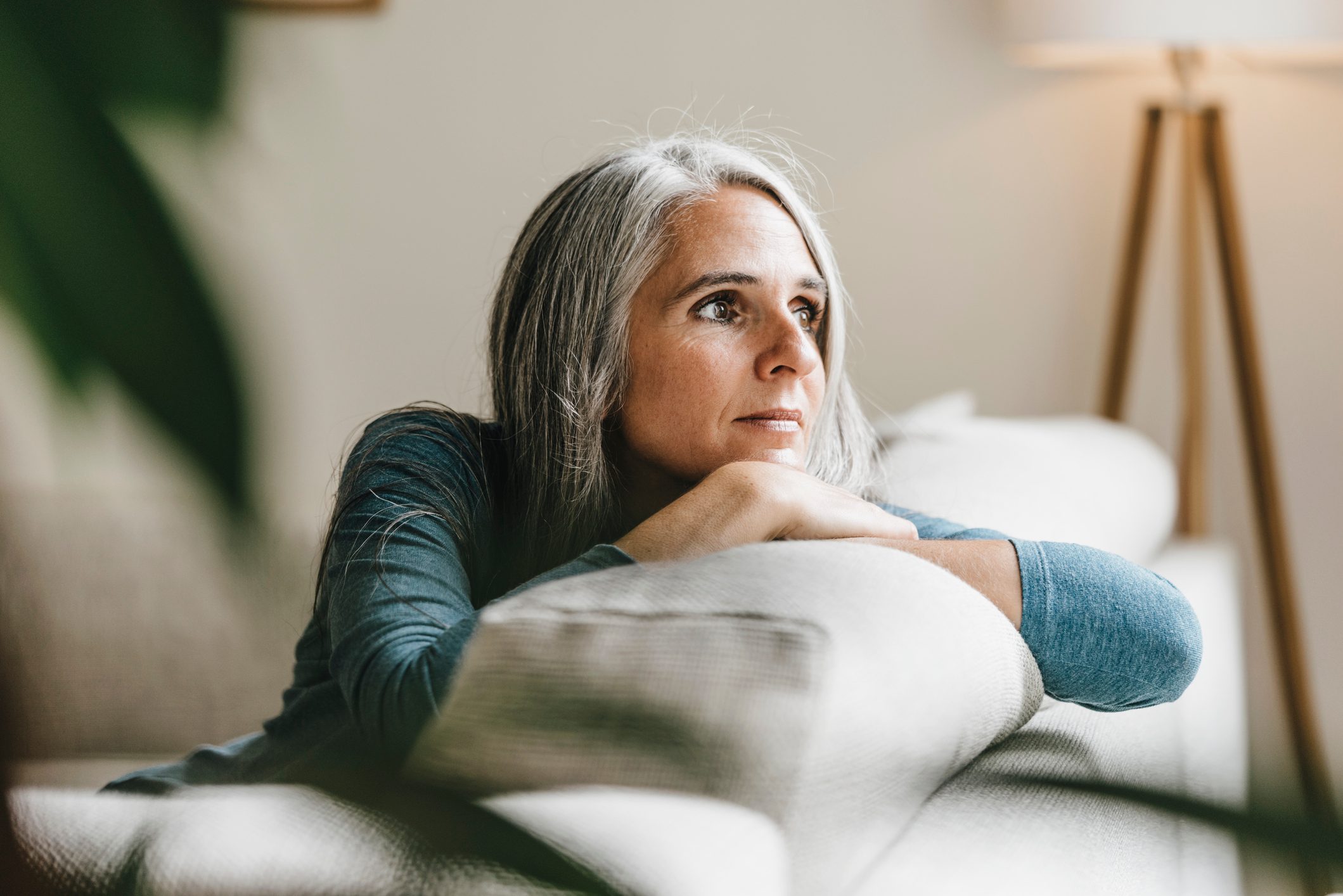 Pensive woman on the couch at home