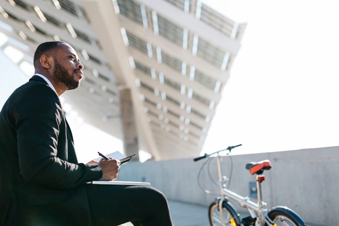 Businessman sitting on stairs with notebook