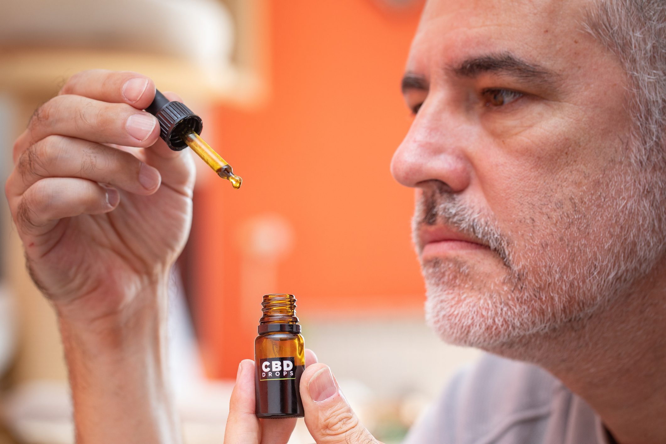 Mature Man Using CBD Oil at Home - Stock Photo