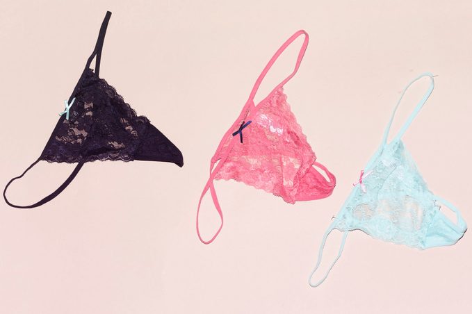 three differents Colors of string lace panties isolated on pink background