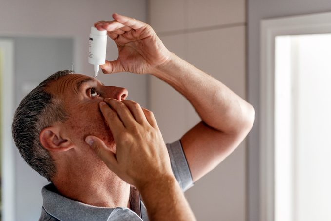 Mature Man Putting Eye Drops In Eyes