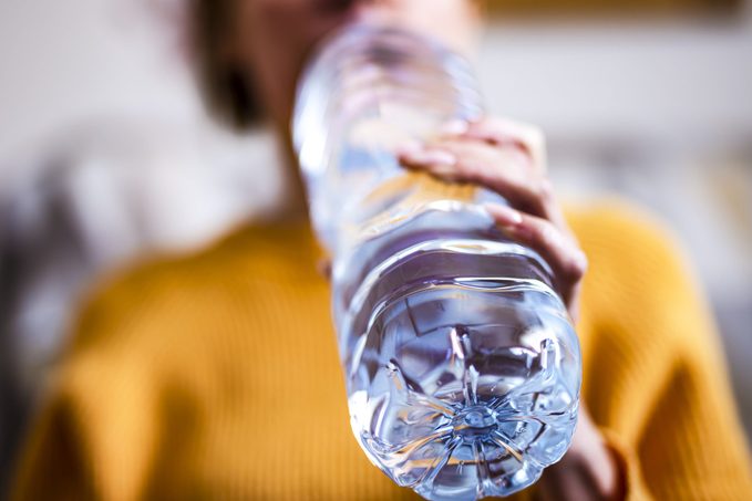 Woman drinking mineral water from the bottle