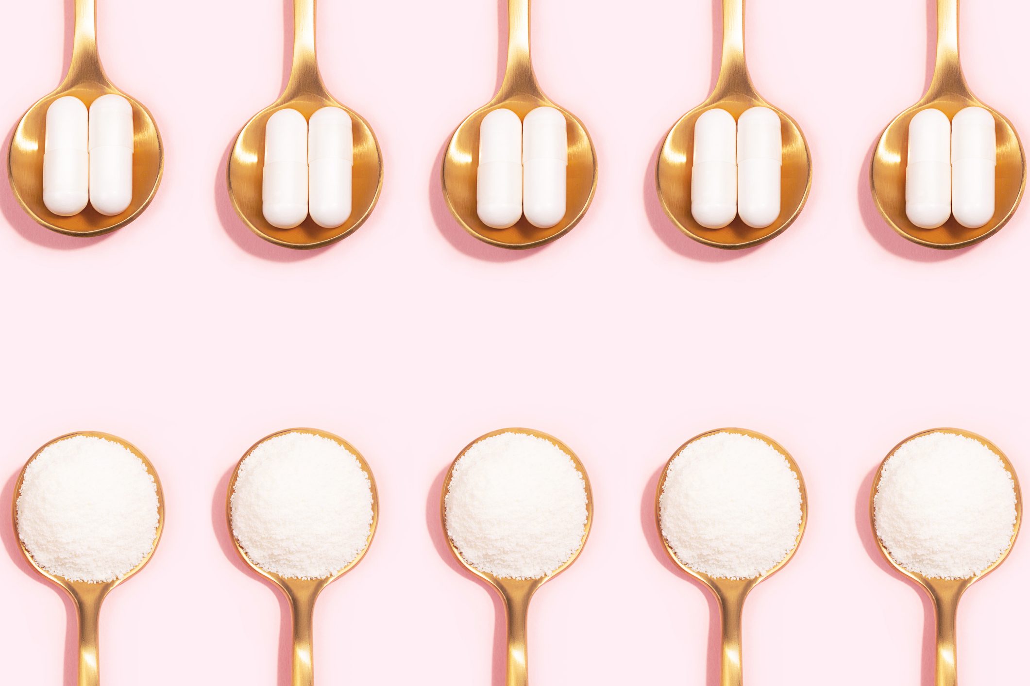 Collagen powder and pills on pink background