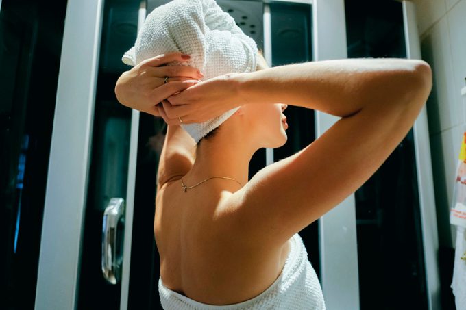 Caucasian woman drying hair with towel