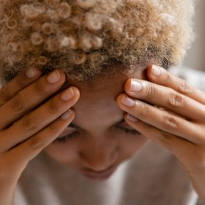 Woman with headache rubbing forehead