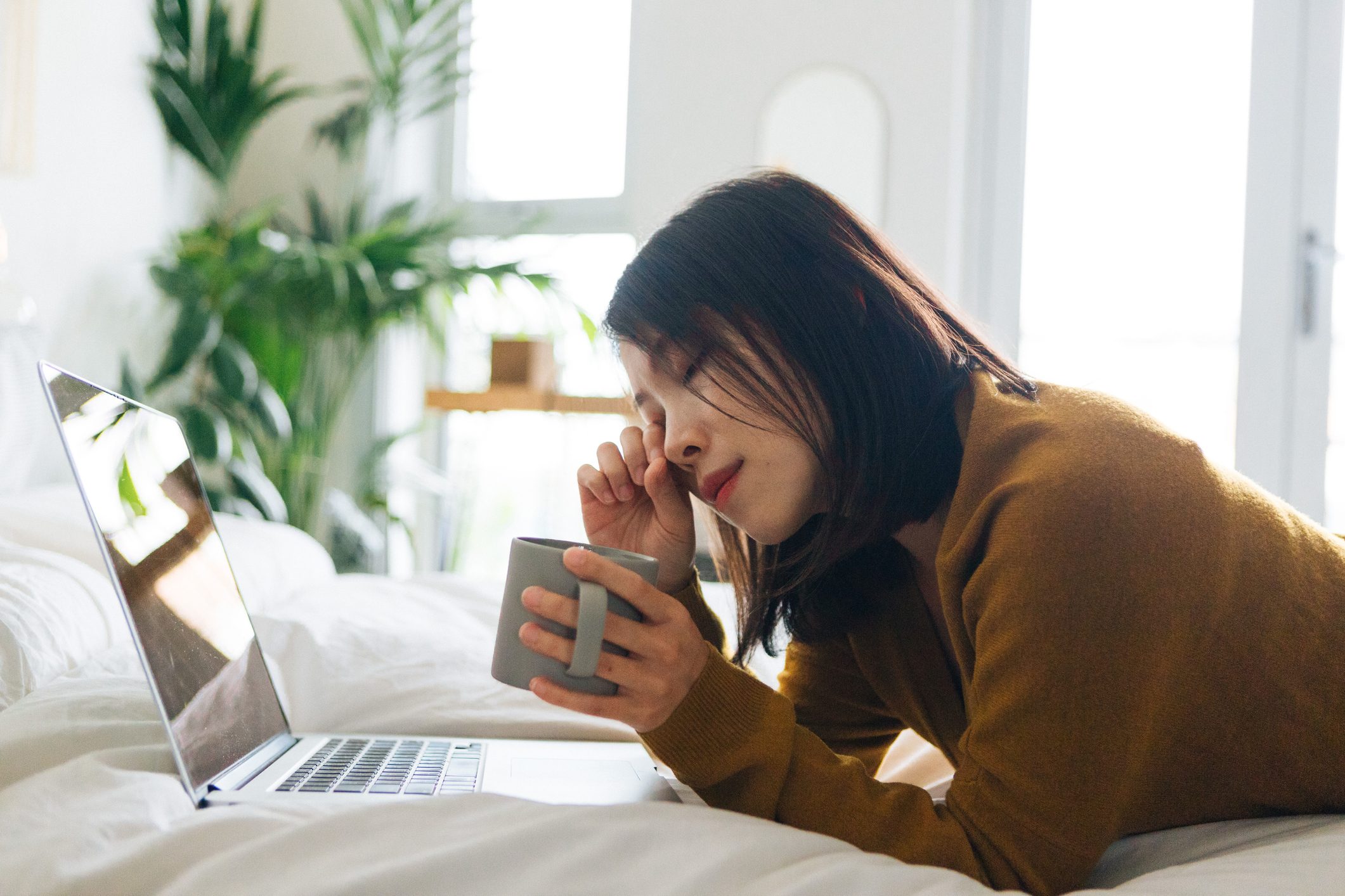 Young woman feeling tired when using laptop working from home