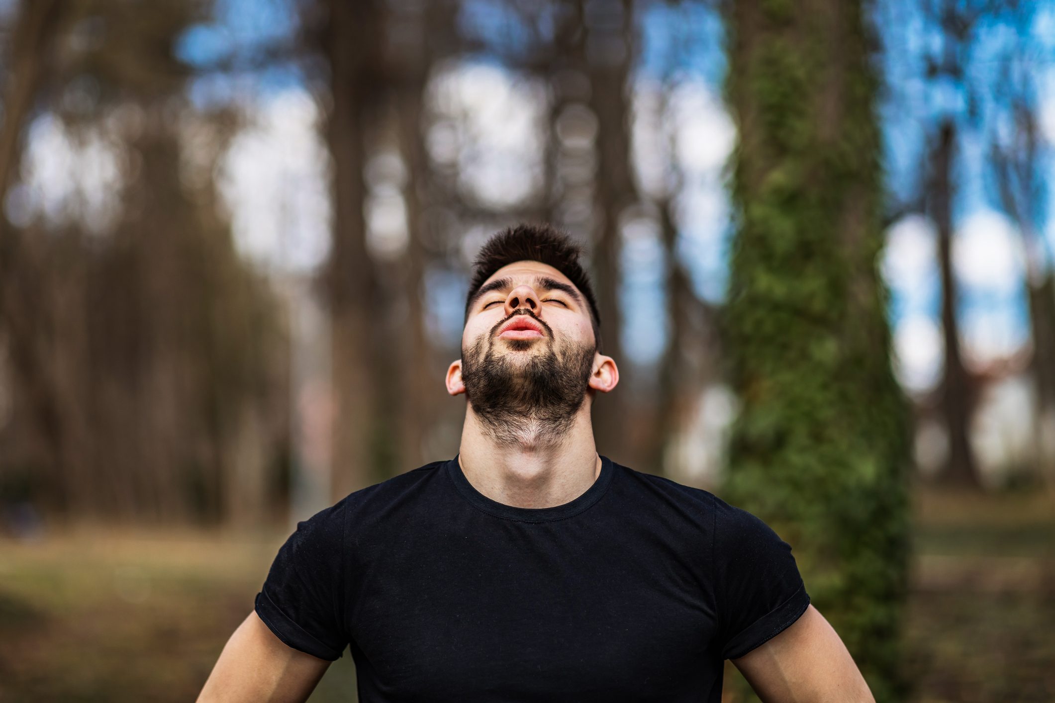 Relaxed man breaths fresh air in a beautiful colorful forest