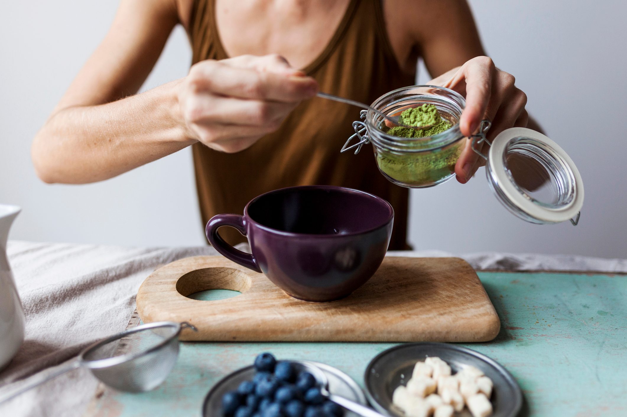 Woman preparing matcha latte at home