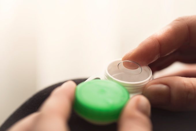 Female hands holding contact lens