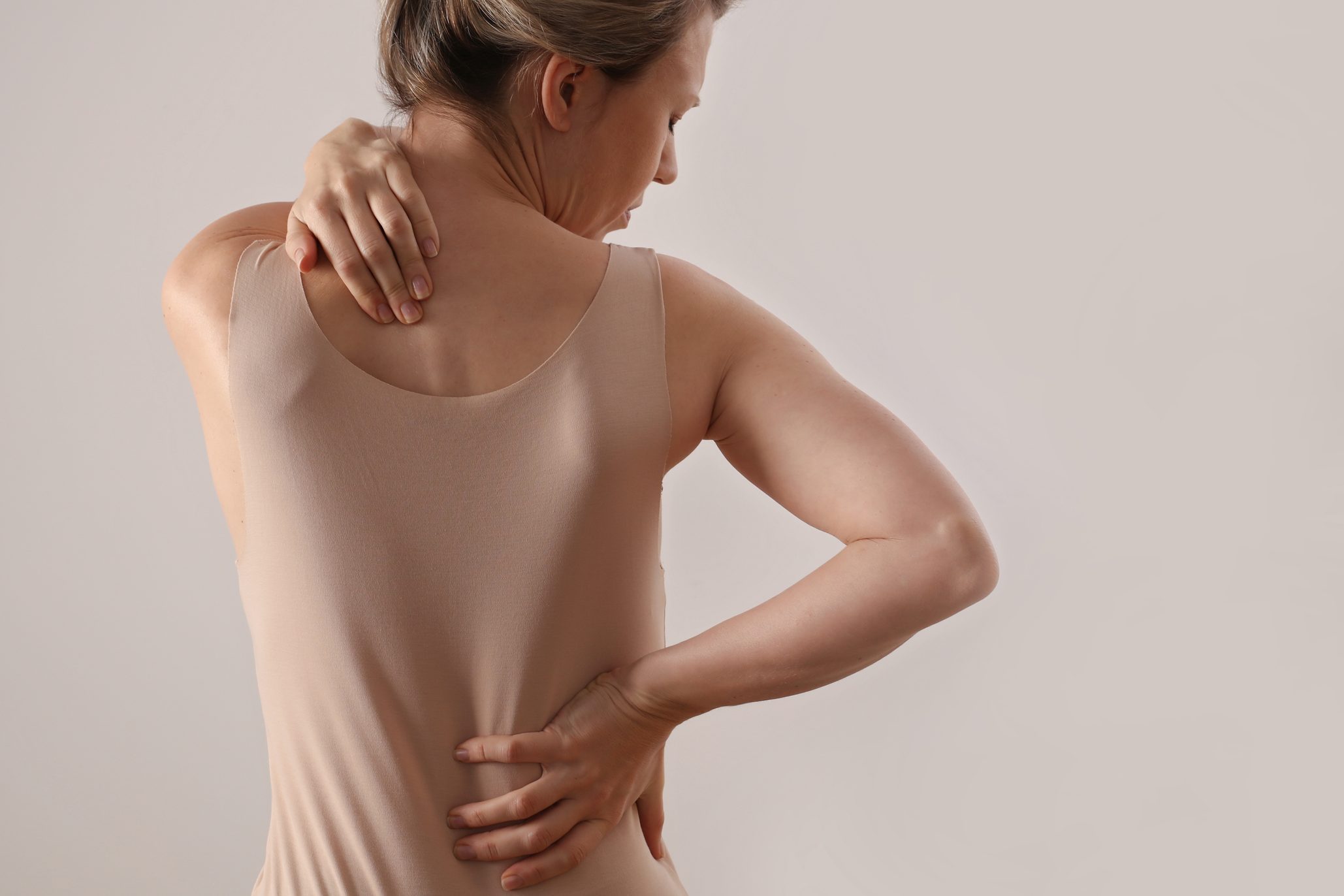 Woman with back and neck pain. Pure posture concept