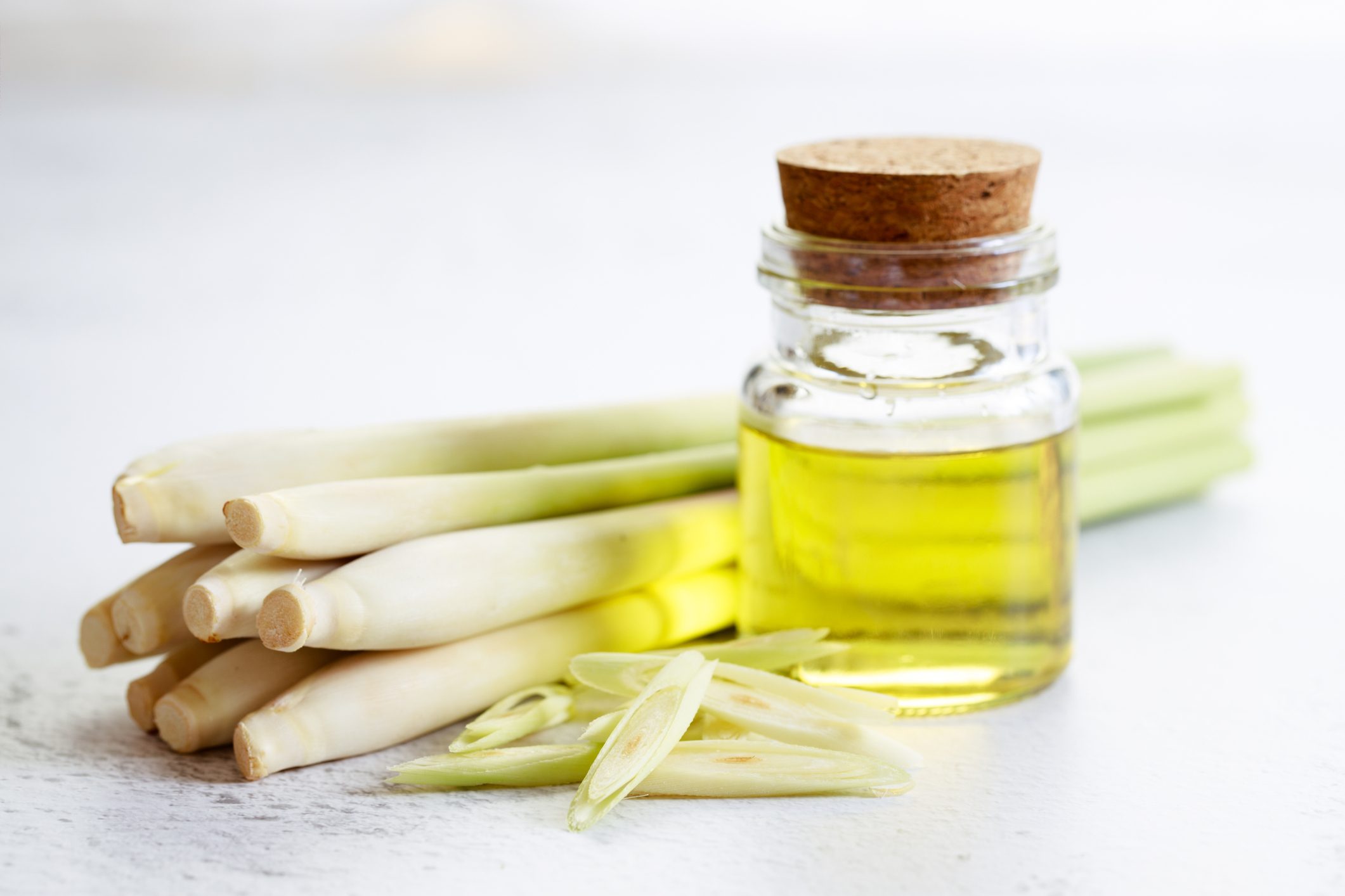 lemongrass essential oil and fresh lemongrass on the white marble table