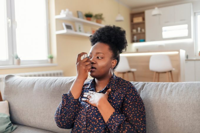 Young Woman With Inhaler Having Asthma Attack, Closeup