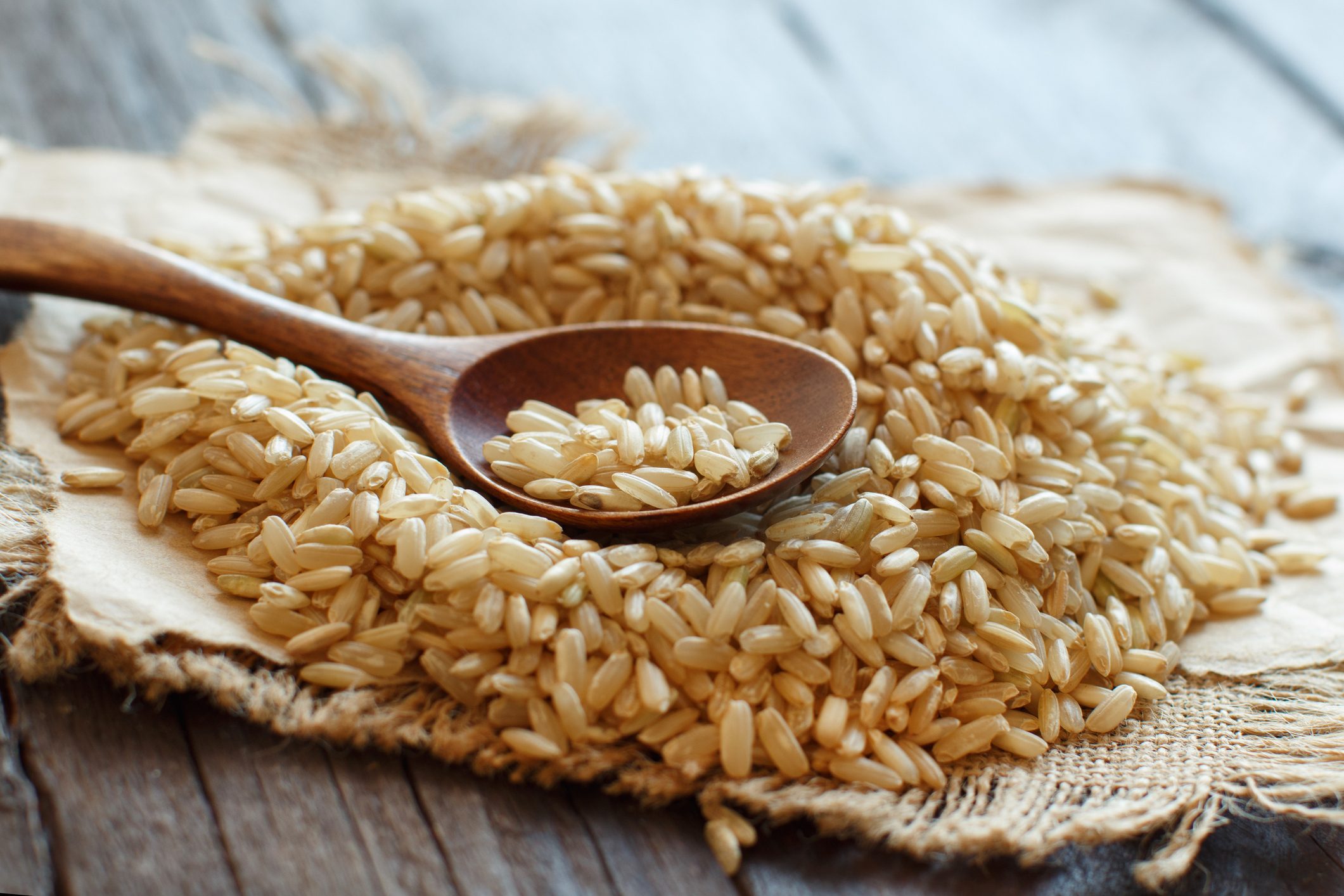 Pile of Brown rice with a wooden spoon