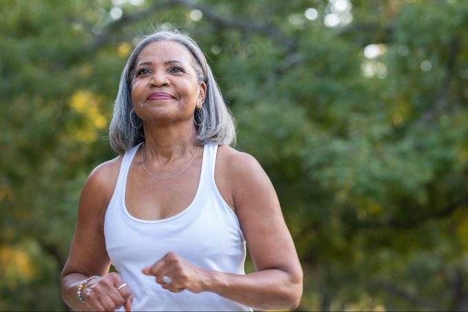Senior woman jogging in public park