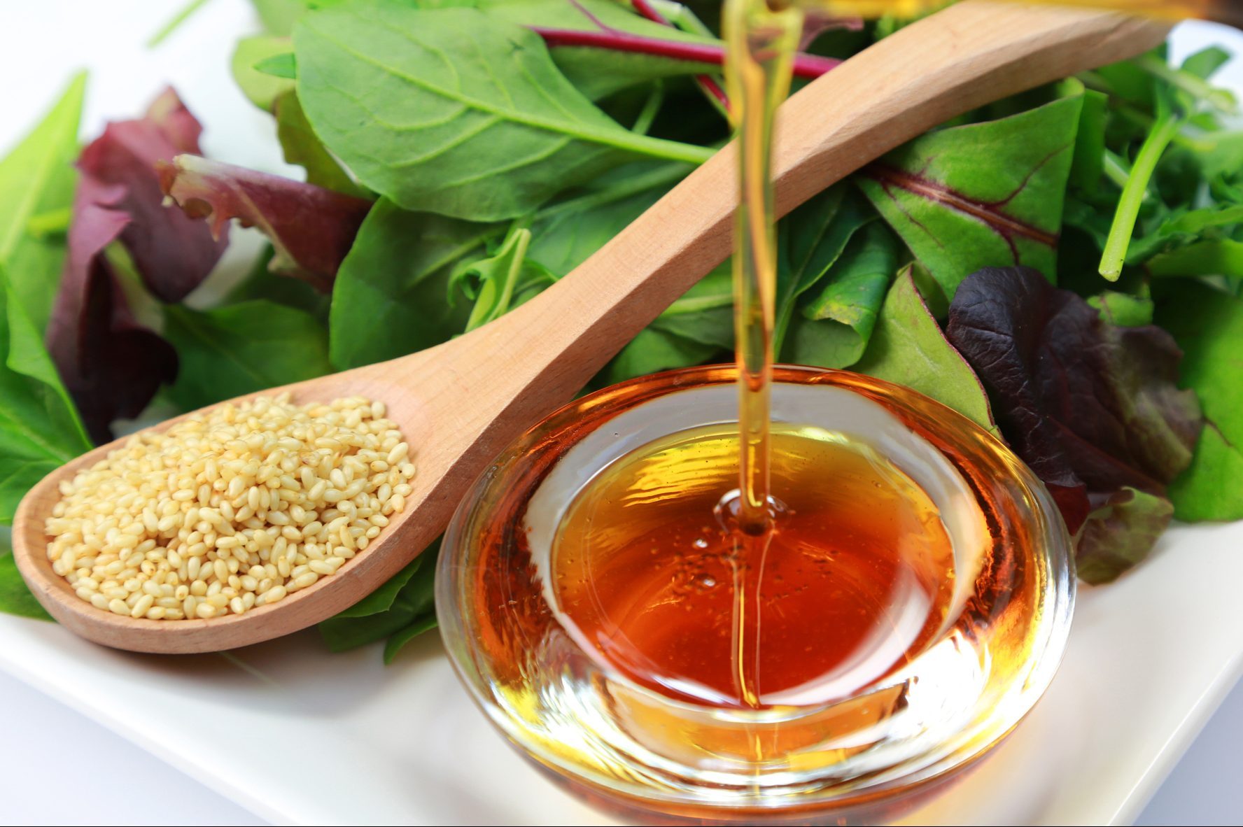 pouring sesame oil on salad