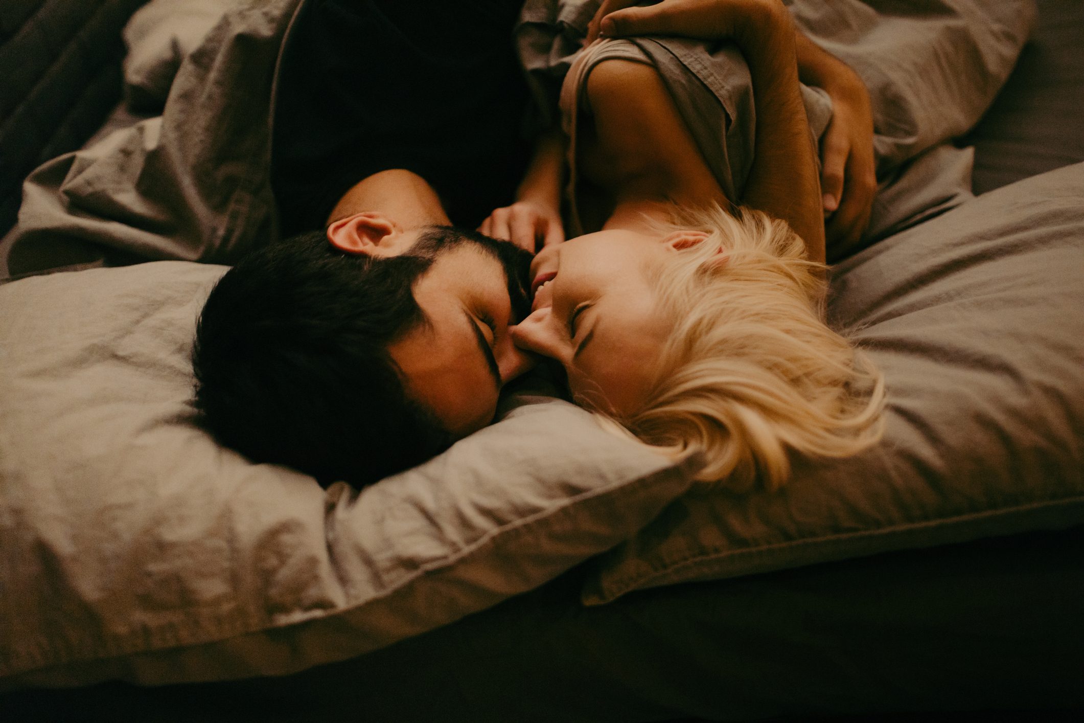 young man and woman lying in bed together