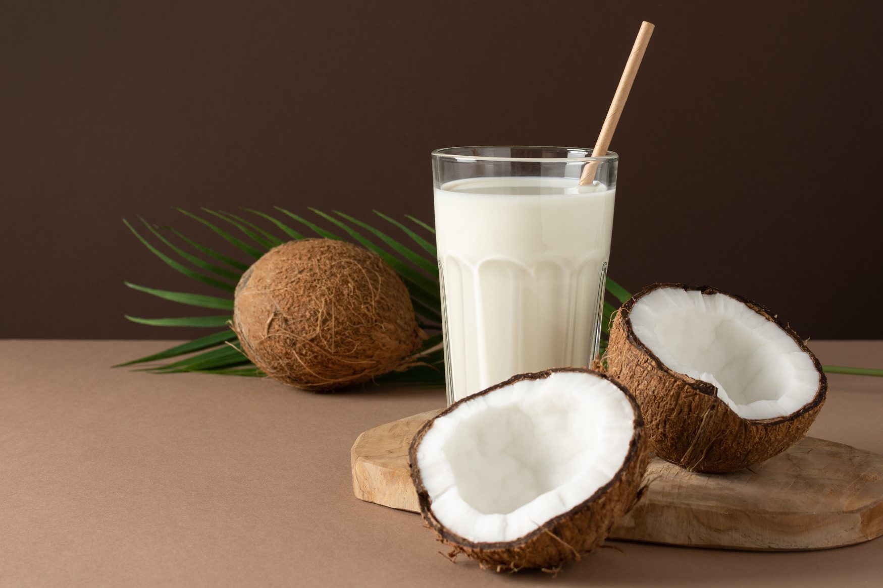 glass of coconut milk on brown background in studio setting