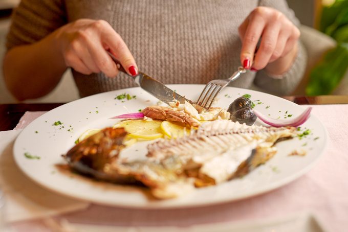 woman eating fish for dinner